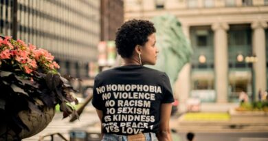 Back view of person wearing t-shirt with empowering message in Chicago street.