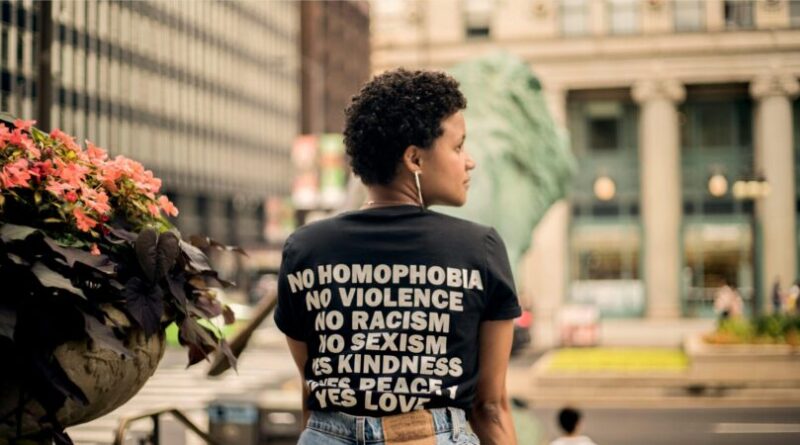 Back view of person wearing t-shirt with empowering message in Chicago street.